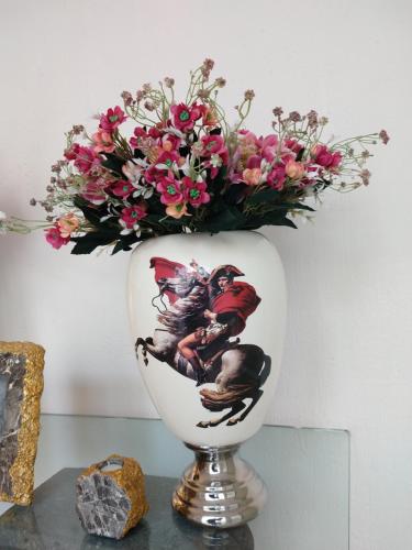 a vase with flowers in it sitting on a table at Residence Las Trojes Cdmx in Mexico City