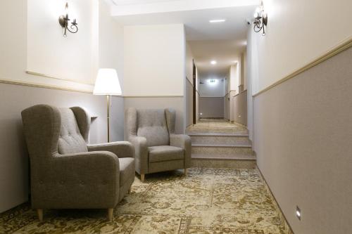 a hallway with two chairs and a stairway with a hallway at Ventus Rosa Boutique Aparthotel in Kraków