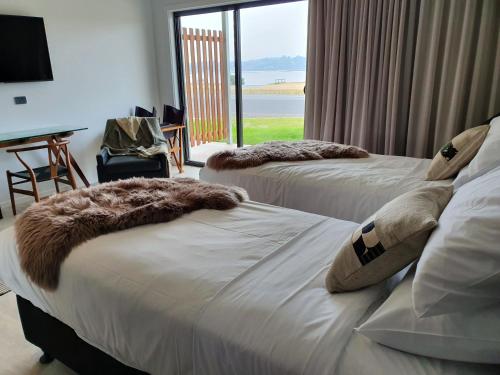two beds in a hotel room with a window at The Seabird in Moruya