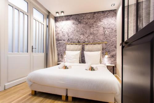 a bedroom with a large bed with white sheets at Dreamyflat - caire ll in Paris
