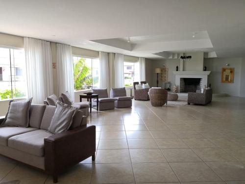 una gran sala de estar con sofás y chimenea. en De Rose Praia Hotel, en Torres