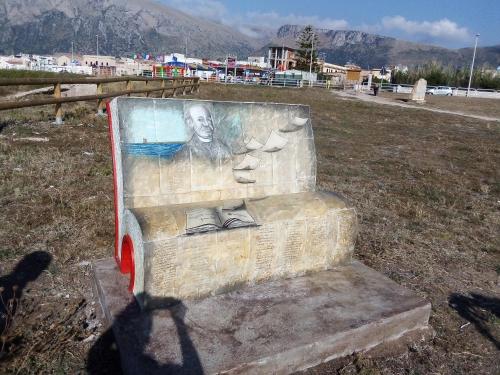 a statue of a man with shoes on a bench at Terra Sinus Holiday House in Terrasini