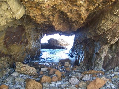 a cave with a river inside of it with rocks at Terra Sinus Holiday House in Terrasini