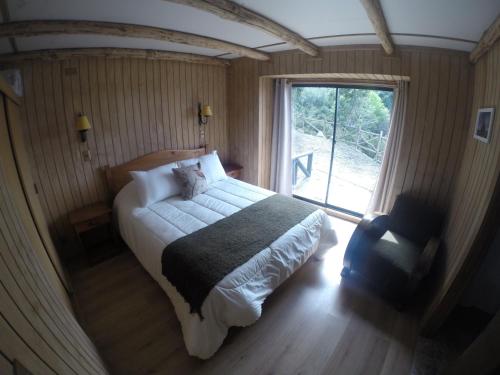 a bedroom with a large bed and a window at Turismo del Bosque in Castro