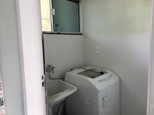 baño pequeño con lavabo y lavadora en Casa temporada Mariscal, Bombinhas-SC, en Bombinhas