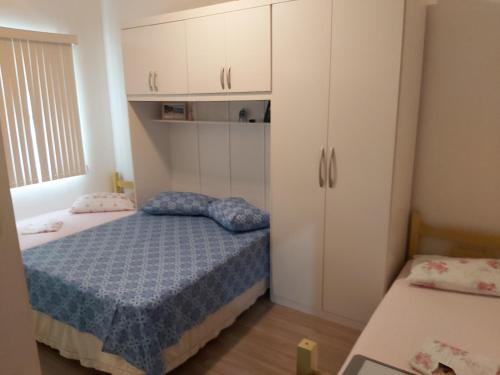 Dormitorio pequeño con cama y armarios blancos en Estilo Residence I, en São Lourenço