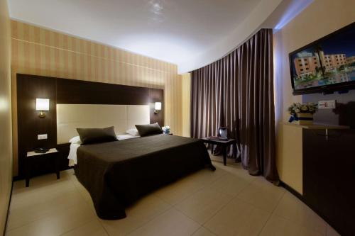 a hotel room with a bed and a television at San Severino Park Hotel & SPA, BW Signature Collection in Mercato San Severino