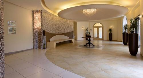 a lobby with a bench and a chandelier at San Severino Park Hotel & SPA, BW Signature Collection in Mercato San Severino