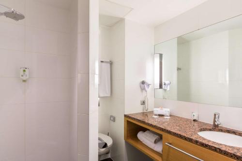 a bathroom with a sink and a mirror at Best Western Plus Monopole Métropole in Strasbourg