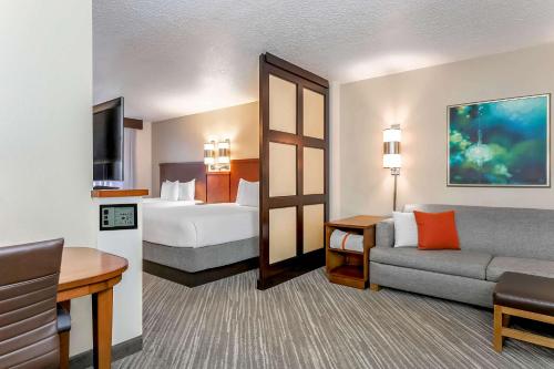 レイクメアリーにあるHyatt Place Lake Mary/Orlando Northのベッドとソファ付きの広いホテルルームです。