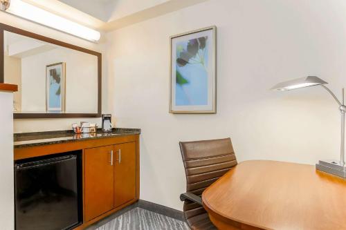 a room with a desk and a table and a table and chair at Hyatt Place Lake Mary/Orlando North in Lake Mary