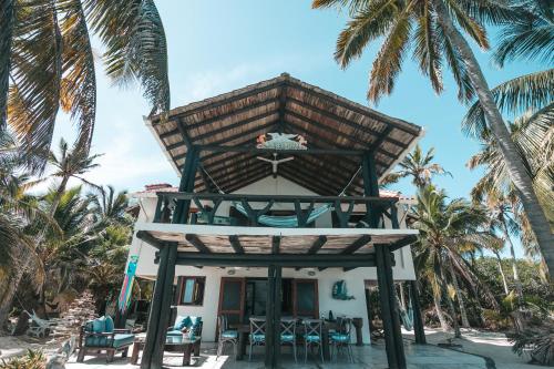 a house on the beach with palm trees at Sal Si Puedes in Tintipan Island