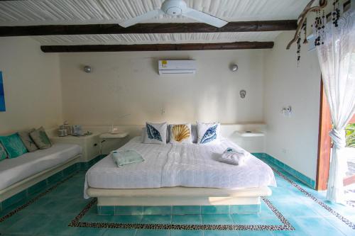 a bedroom with a bed and a couch at Tintipan Cabana SalSiPuedes in Tintipan Island