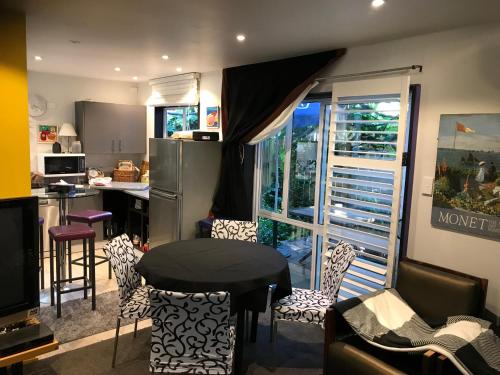 cocina con mesa, sillas y barra en Pryor Haven Chalet Green Retreat in a Lovely Place en Christchurch