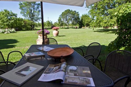 a table with an umbrella and a book on it at Monastero San Silvestro in Cortona