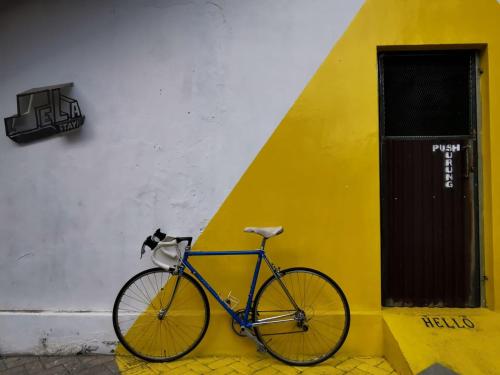 uma bicicleta estacionada ao lado de um edifício amarelo e branco em Sela Stay em Yogyakarta