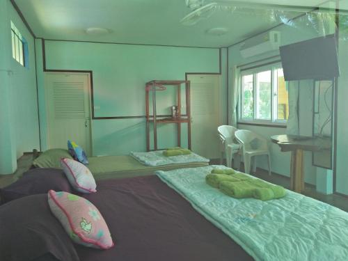 a bedroom with two beds with pillows on it at Happy Days Resort in Ko Mak