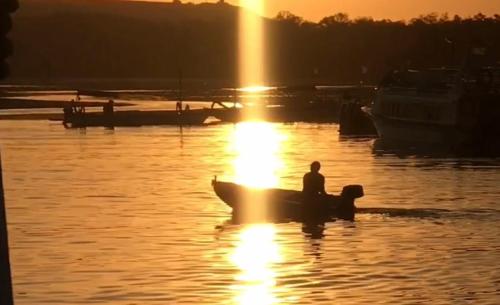 a man in a boat in the water at sunset at New Danas Canggu Guest House in Kerobokan