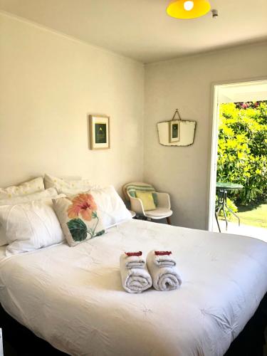 a bedroom with a large white bed with towels on it at Sunny, Serene Studio @ Motueka in Motueka