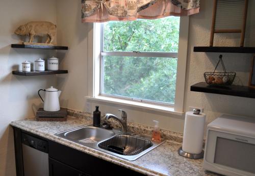 eine Küchentheke mit einem Waschbecken und einem Fenster in der Unterkunft Lydias Loft in Ingram