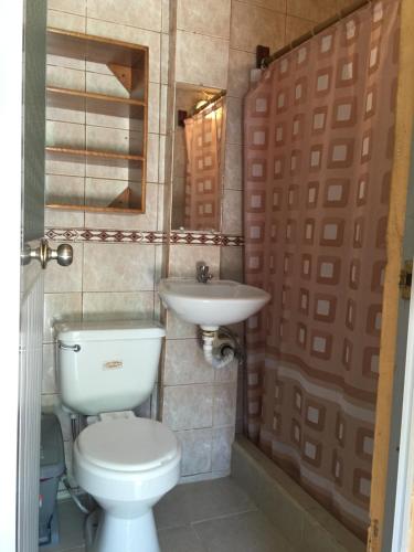 a bathroom with a toilet and a sink at A Welcome Break Hostal in Tena