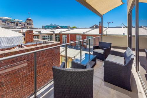 a patio area with chairs and a bench at Bannister 22 Hotel in Fremantle