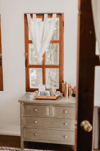 a dresser with a window and a plate on it at Korakia Pensione in Palm Springs