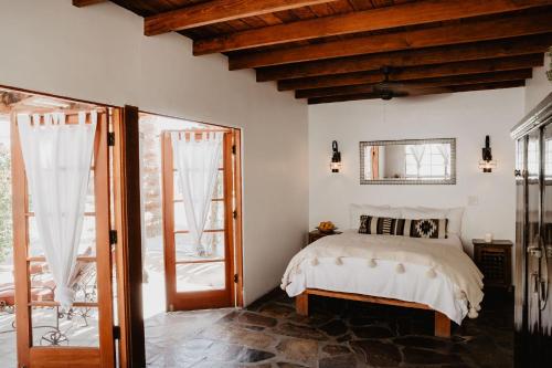 a bedroom with a bed and some windows at Korakia Pensione in Palm Springs
