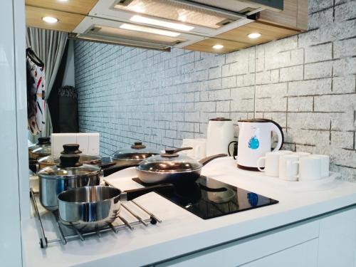 a kitchen with pots and pans on a stove at Plaza Arkadia Desa Parkcity by KLhomesweet in Kuala Lumpur