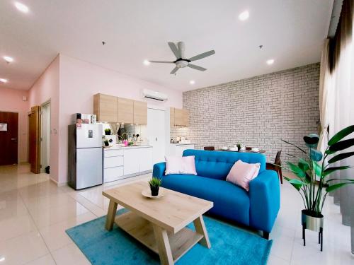 a living room with a blue couch and a table at Plaza Arkadia Desa Parkcity by KLhomesweet in Kuala Lumpur
