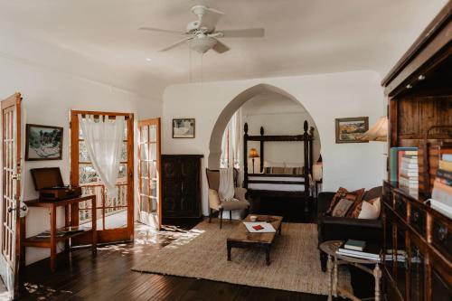 a living room with a ceiling fan and a bedroom at Korakia Pensione in Palm Springs