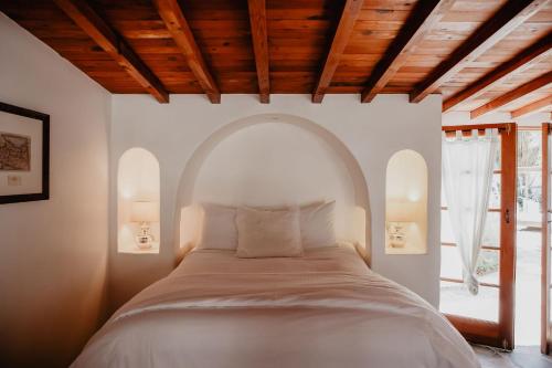 a bedroom with a large bed with an arched window at Korakia Pensione in Palm Springs