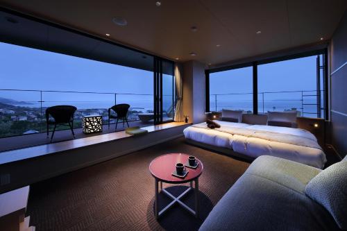館山的住宿－The Shinra，一间卧室配有一张床、一张沙发和大窗户