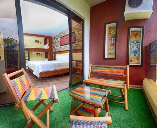 a room with two chairs and a bed and a bedroom at Hotel Castillo Resort in San Gil