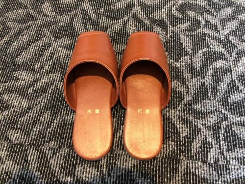 a pair of brown boots sitting on a bed at Ai Hotel Keikyu Kamata in Tokyo
