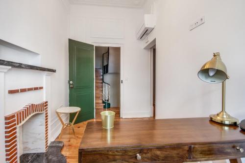 a kitchen with a wooden table and a green door at Saldanha Pool & Garden in Lisbon