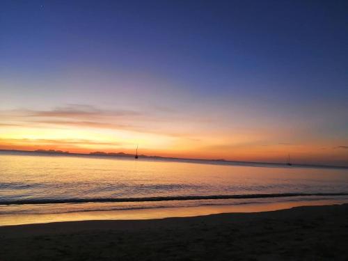 a sunset on the beach with the ocean at Koh Jum Delight Beach in Ko Jum