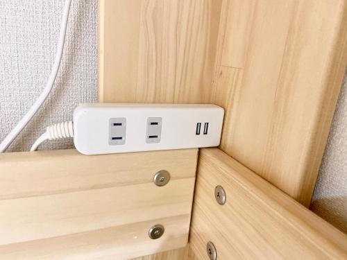 a light wood cabinet with a lightswitch on it at Upper Hotel Ryogoku in Tokyo