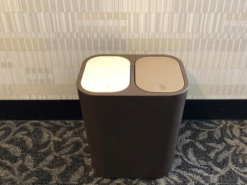 a black trash can sitting in a room at Ai Hotel Keikyu Kamata in Tokyo