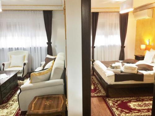 a bedroom with a bed and a couch and a chair at My Hotel Apartments in Bucharest