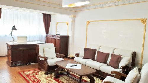 a living room with a couch and chairs and a table at My Hotel Apartments in Bucharest