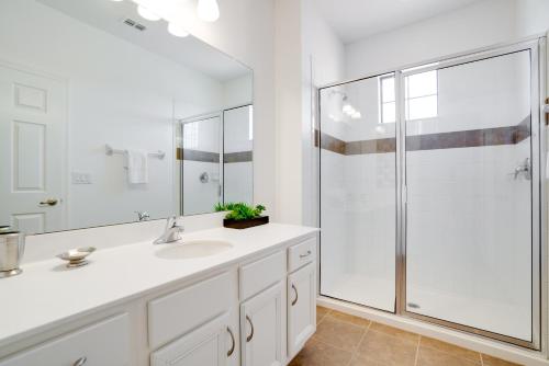 a white bathroom with a shower and a sink at Large family friendly Vacation Home, Private Pool, Golf course location, Nr Orlando Disney Parks Florida in Davenport