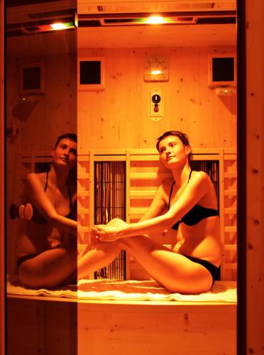 two women in bathing suits sitting on a bed in a mirror at Landhotel Haagerhof in Aigen im Mühlkreis
