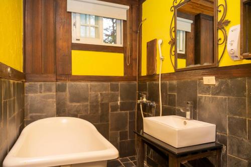a bathroom with a sink and a toilet and a mirror at Provence Rose Lodge in Renai
