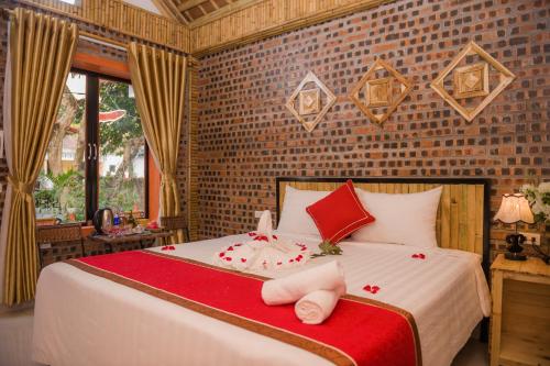 a bedroom with a large bed with red pillows at Tam Coc Three Princess Homestay in Ninh Binh