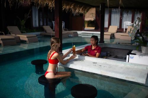 a man and a woman in a swimming pool at Kayangan Villa Ubud in Tegalalang