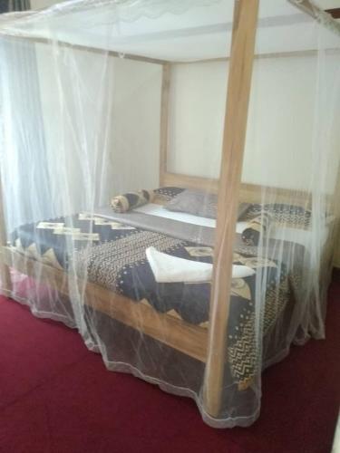 um quarto com uma cama de dossel e redes mosquiteiras em KERESI BUDGET BLOCK at PENIEL em Entebbe