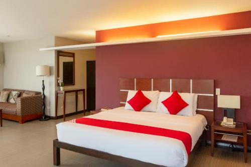 um quarto com uma cama grande e almofadas vermelhas em East View Hotel em Bacolod