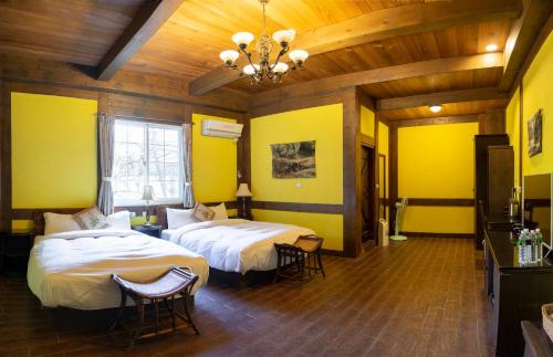 a hotel room with two beds and a chandelier at Provence Rose Lodge in Renai
