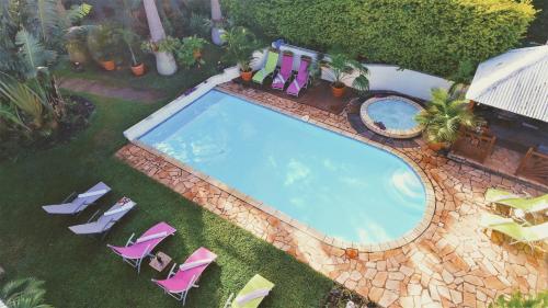 an overhead view of a swimming pool with lounge chairs and a pool at Villa arbre du voyageur, 4 étoiles et 4 clévacances in LʼEntre-Deux